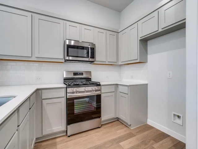 a kitchen with white cabinets and stainless steel appliances