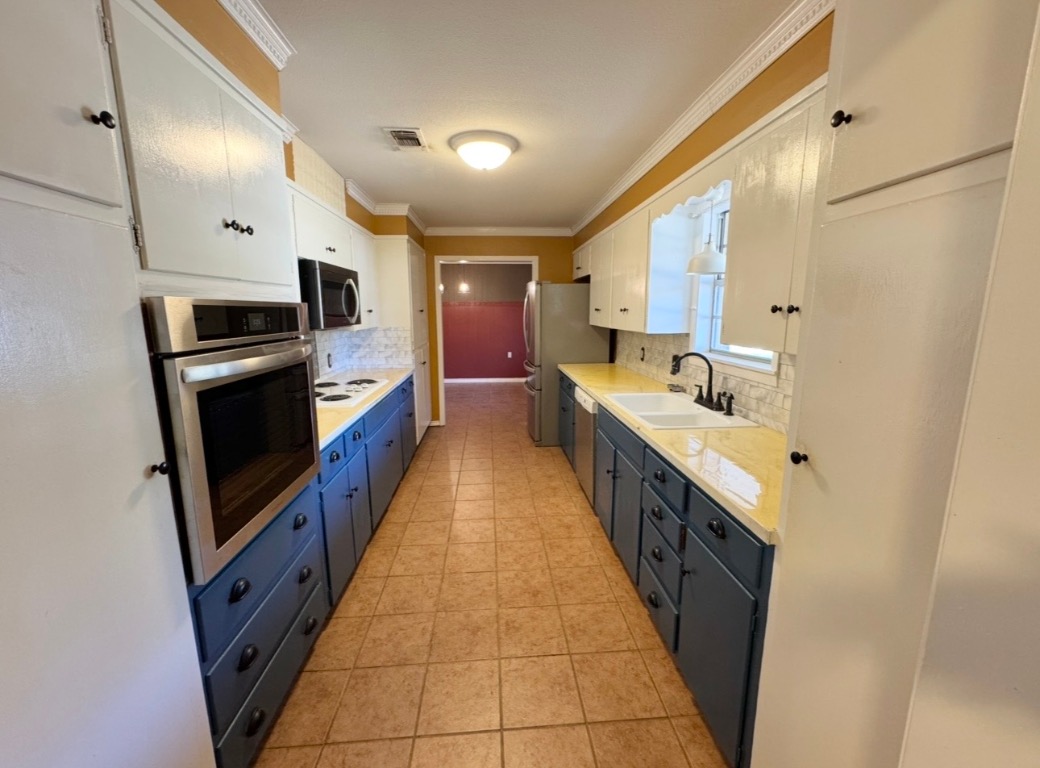 1225 Lake Terrace Drive Elgin, TX 78621 - Photo 8 of 28 a large kitchen with a large counter top a sink a stove and a refrigerator