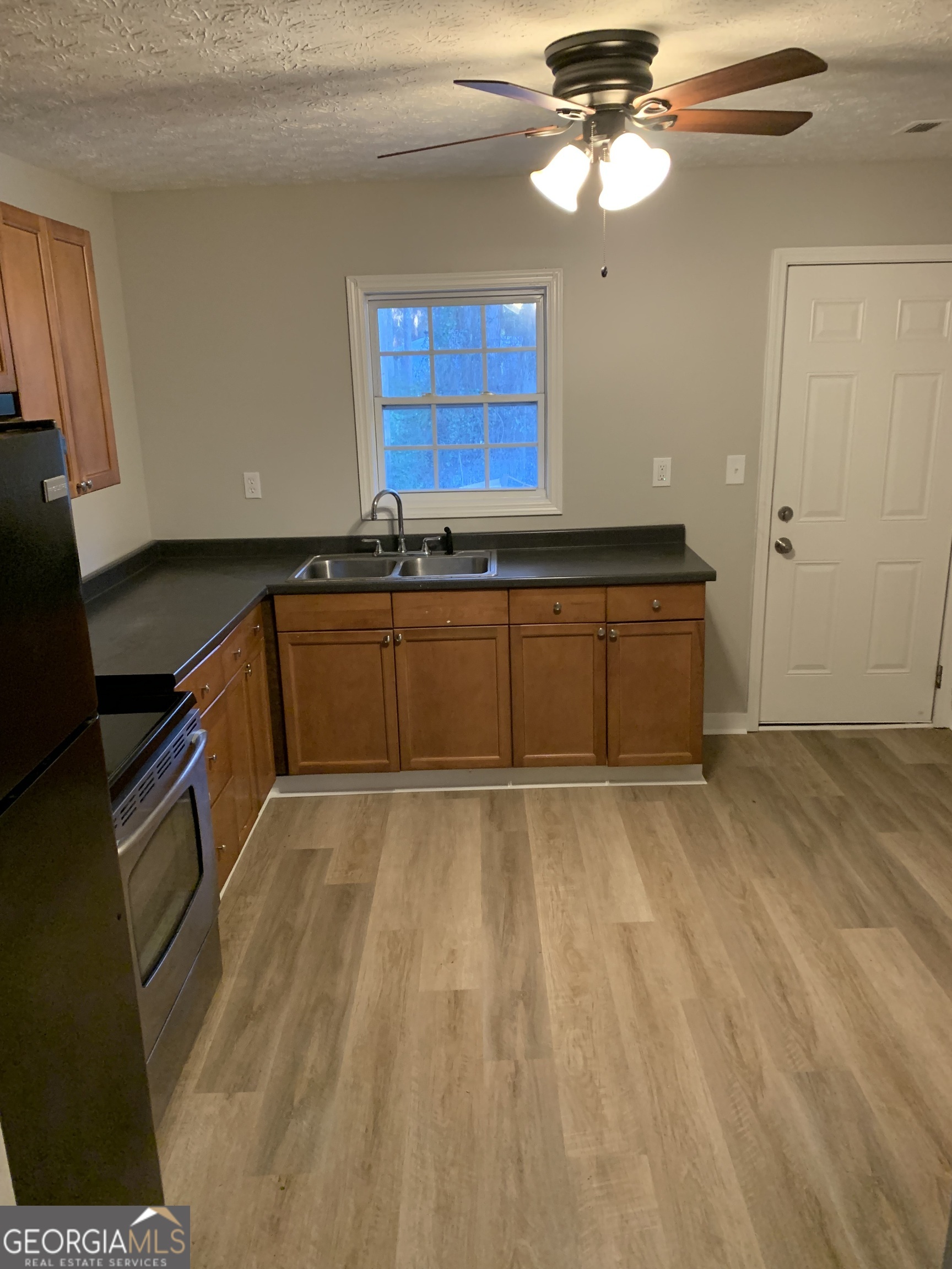 7181 Puckett Street Southwest Covington, GA 30014 - Photo 13 of 18 a kitchen with granite countertop a sink cabinets stainless steel appliances and a window