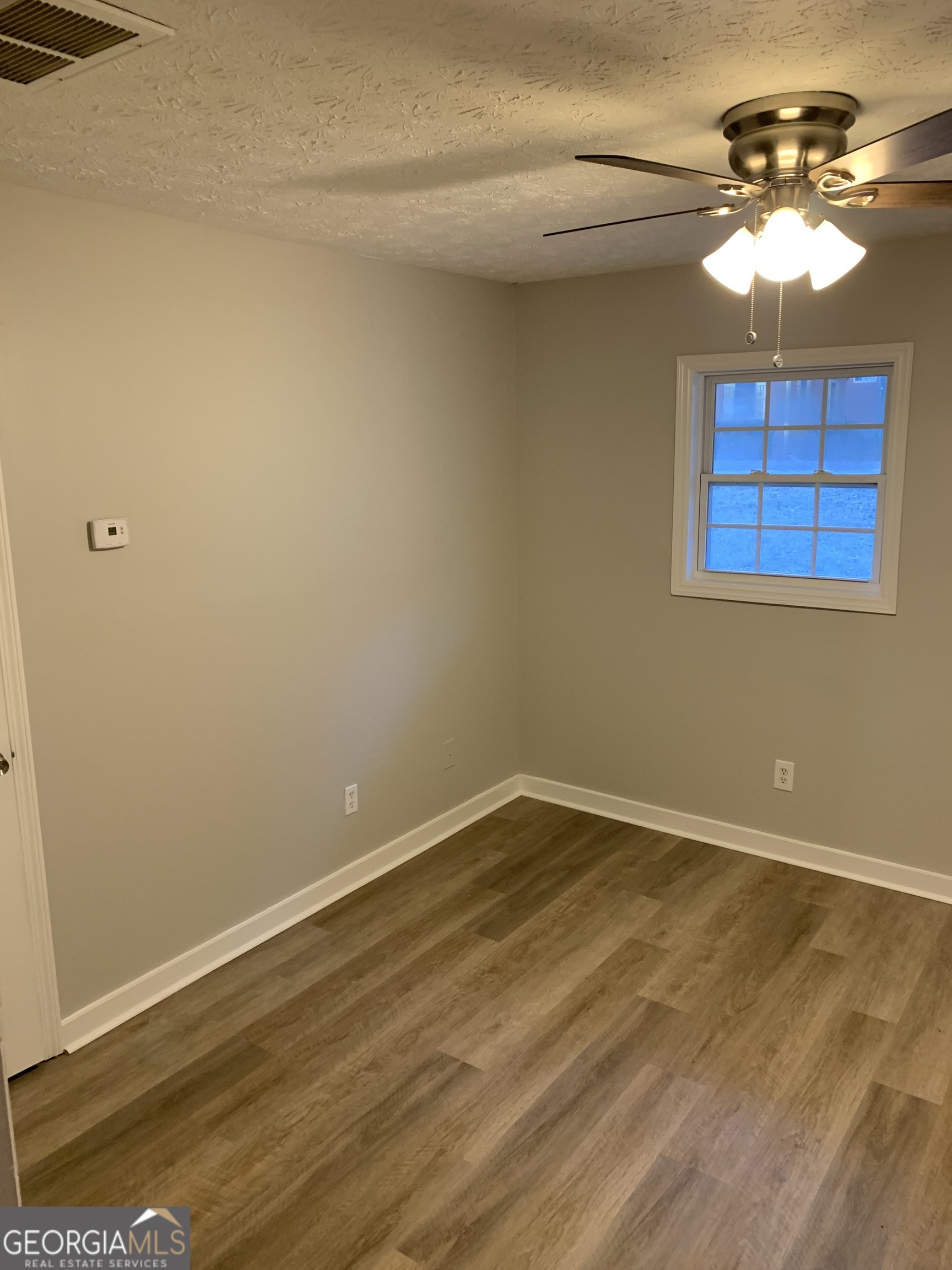 7181 Puckett Street Southwest Covington, GA 30014 - Photo 15 of 18 a view of an empty room with a chandelier fan