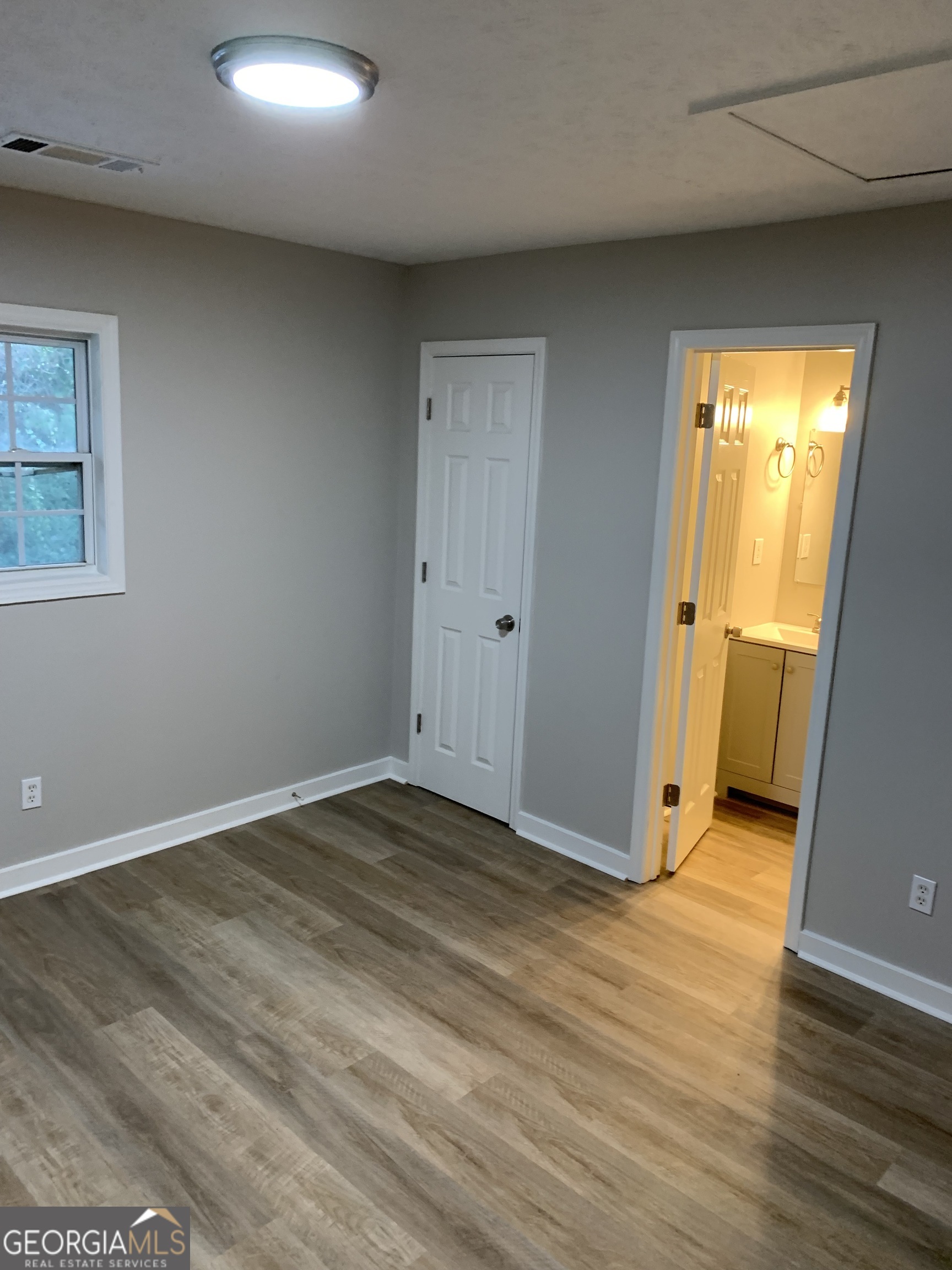 7181 Puckett Street Southwest Covington, GA 30014 - Photo 2 of 18 an empty room with wooden floor and closet