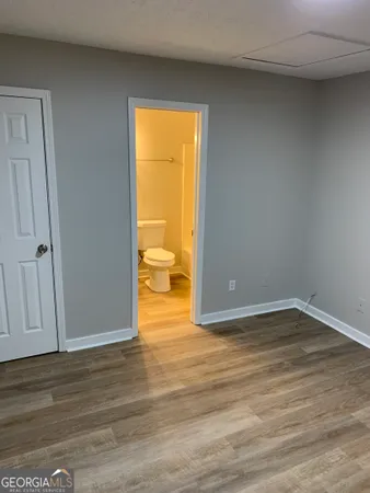 a view of an empty room and wooden floor and a window