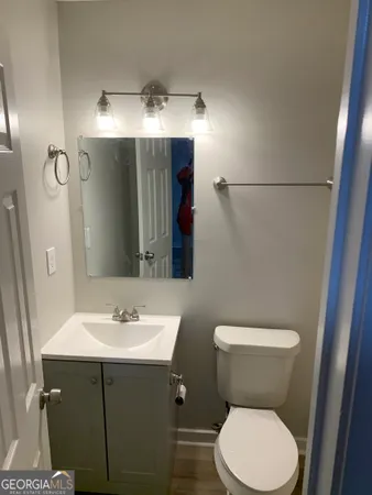 a bathroom with a toilet sink and mirror