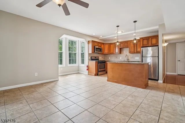 a open kitchen with stainless steel appliances granite countertop a refrigerator and a stove top oven