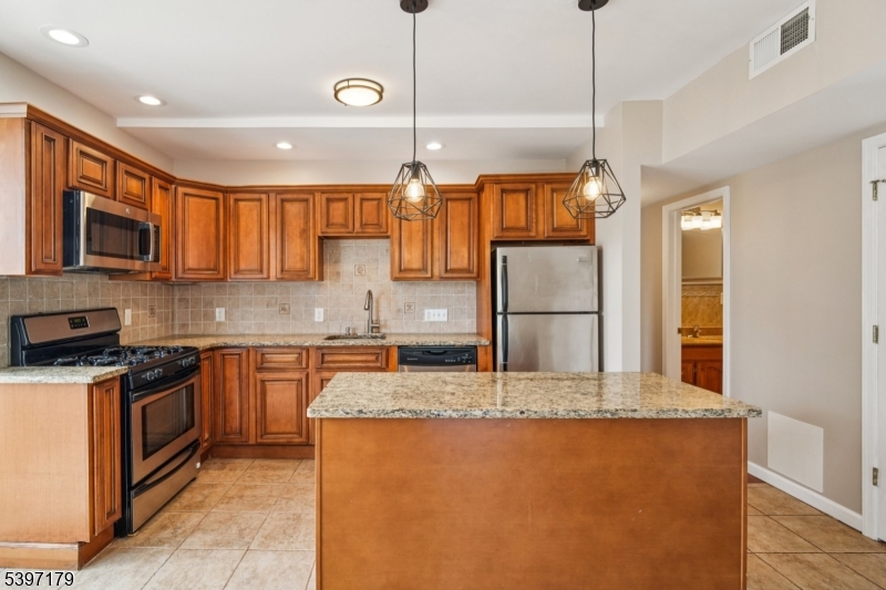 141 Walnut Street, Unit 2 Montclair, NJ 07042 - Photo 8 of 23 a kitchen with stainless steel appliances granite countertop a stove a sink and a refrigerator
