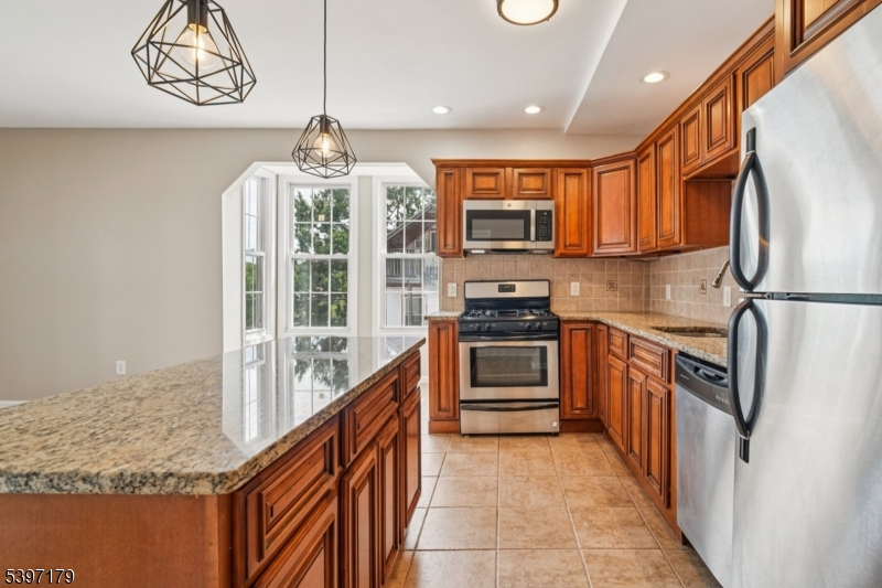 141 Walnut Street, Unit 2 Montclair, NJ 07042 - Photo 9 of 23 a kitchen with stainless steel appliances granite countertop a refrigerator and a stove top oven