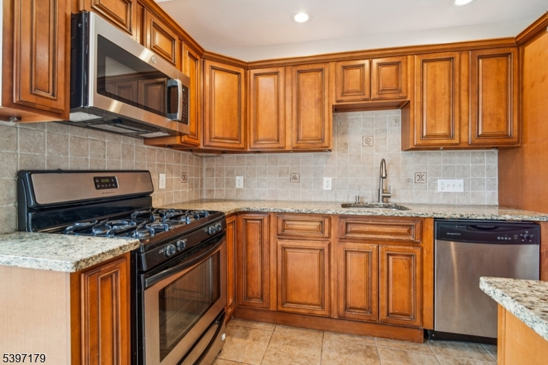 141 Walnut Street, Unit 2 Montclair, NJ 07042 - Photo 10 of 23 a kitchen with granite countertop a stove sink and cabinets