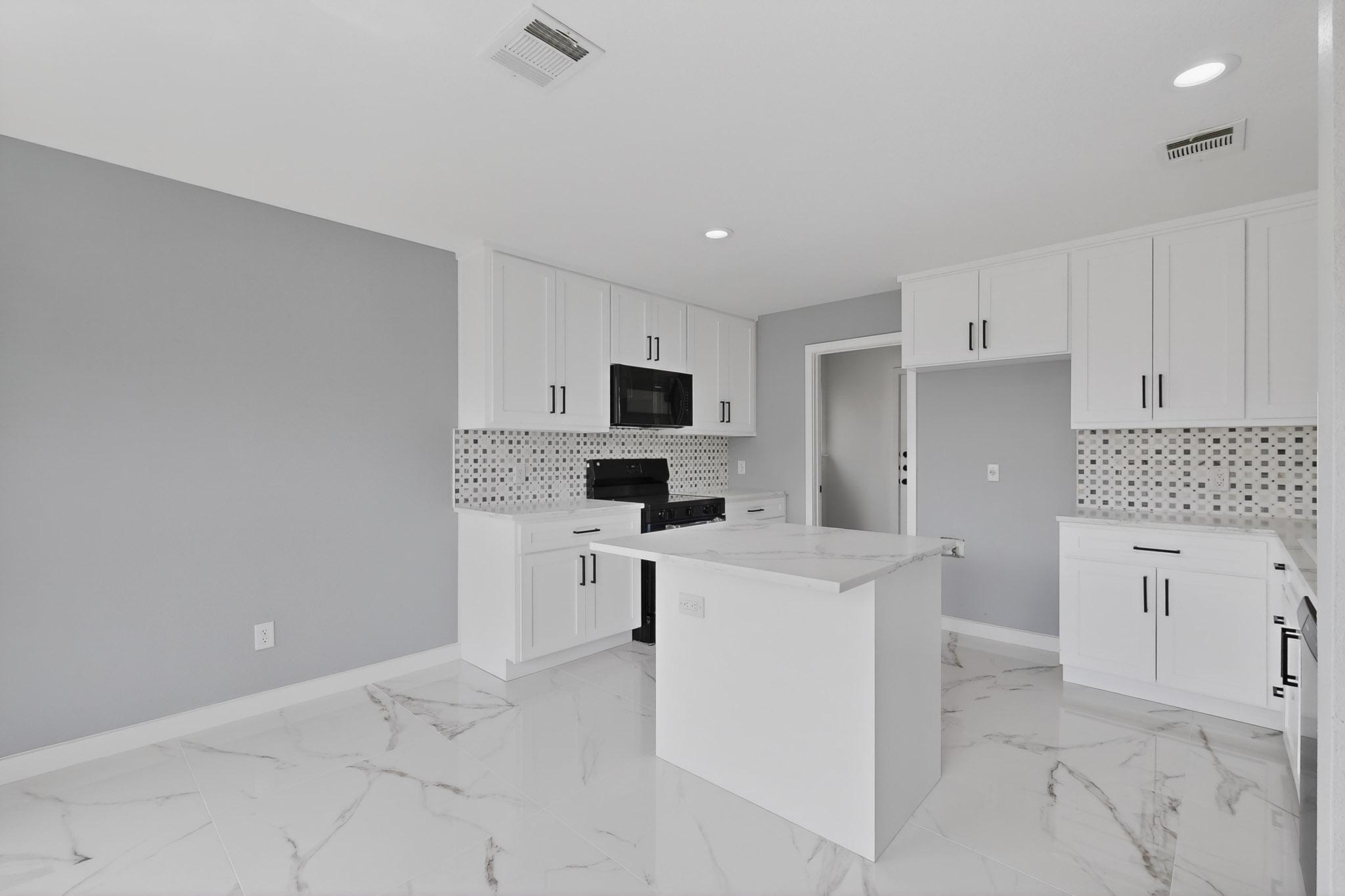 1200 Apollo Circle Round Rock, TX 78664 - Photo 14 of 45 a kitchen with white cabinets and stainless steel appliances
