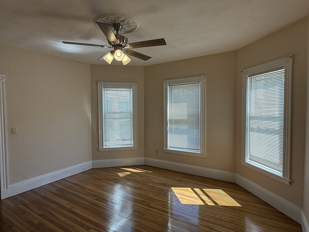 4 Dever Street, Unit 1 Boston, MA 02122 - Photo 12 of 22 a view of an empty room with wooden floor and a window