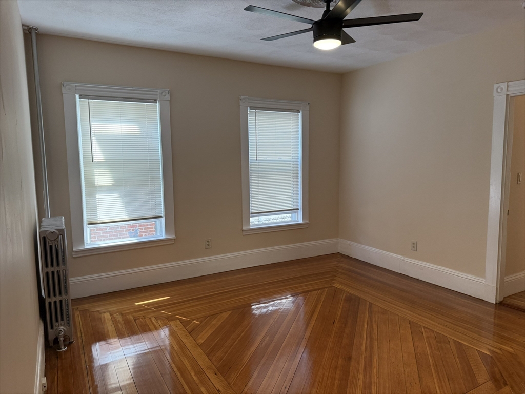 4 Dever Street, Unit 1 Boston, MA 02122 - Photo 13 of 22 a view of empty room with wooden floor and fan