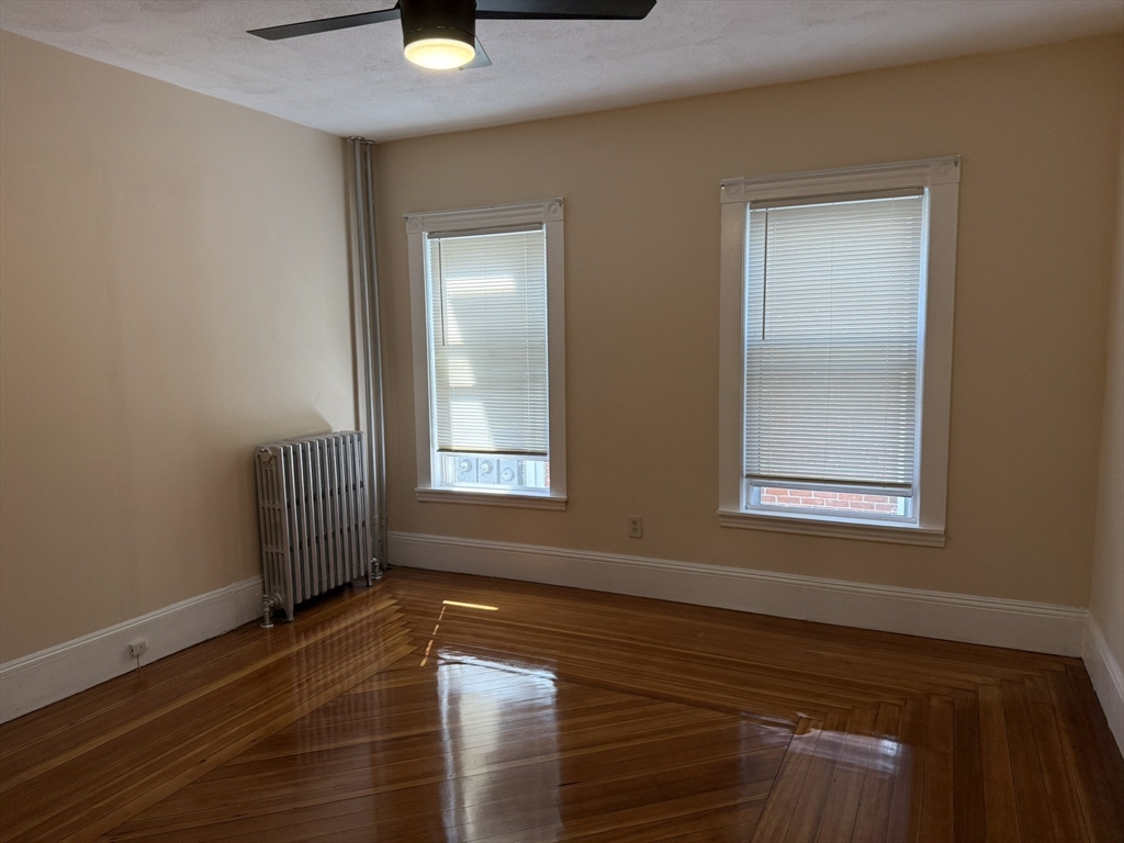 4 Dever Street, Unit 1 Boston, MA 02122 - Photo 14 of 22 a view of an empty room with window and wooden floor
