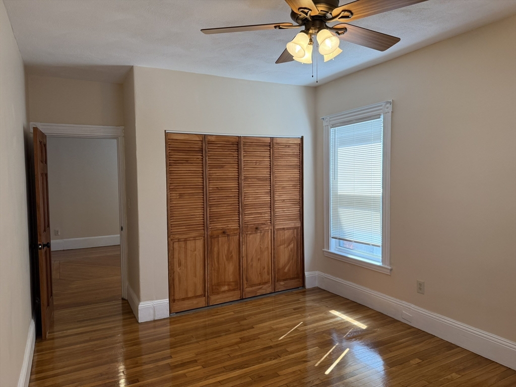 4 Dever Street, Unit 1 Boston, MA 02122 - Photo 16 of 22 a view of an empty room with a ceiling fan and a window