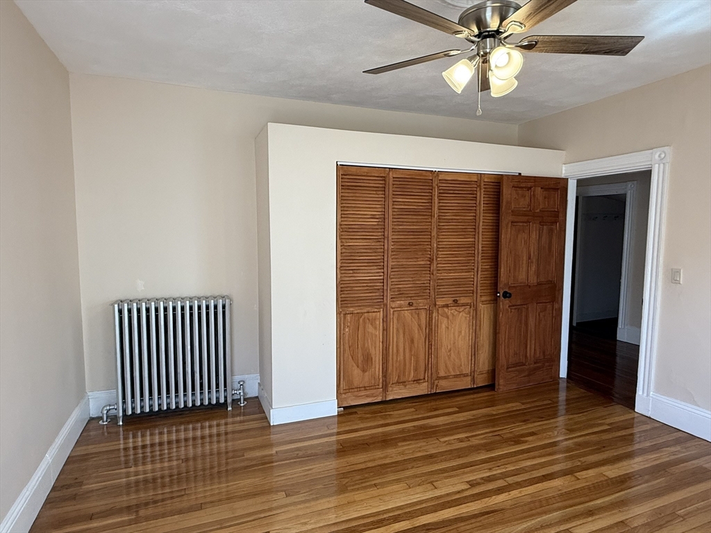 4 Dever Street, Unit 1 Boston, MA 02122 - Photo 18 of 22 an empty room with wooden floor fan and windows
