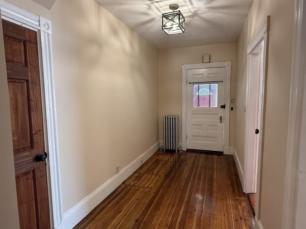 4 Dever Street, Unit 1 Boston, MA 02122 - Photo 21 of 22 a view of a hallway with wooden floor and a bathroom