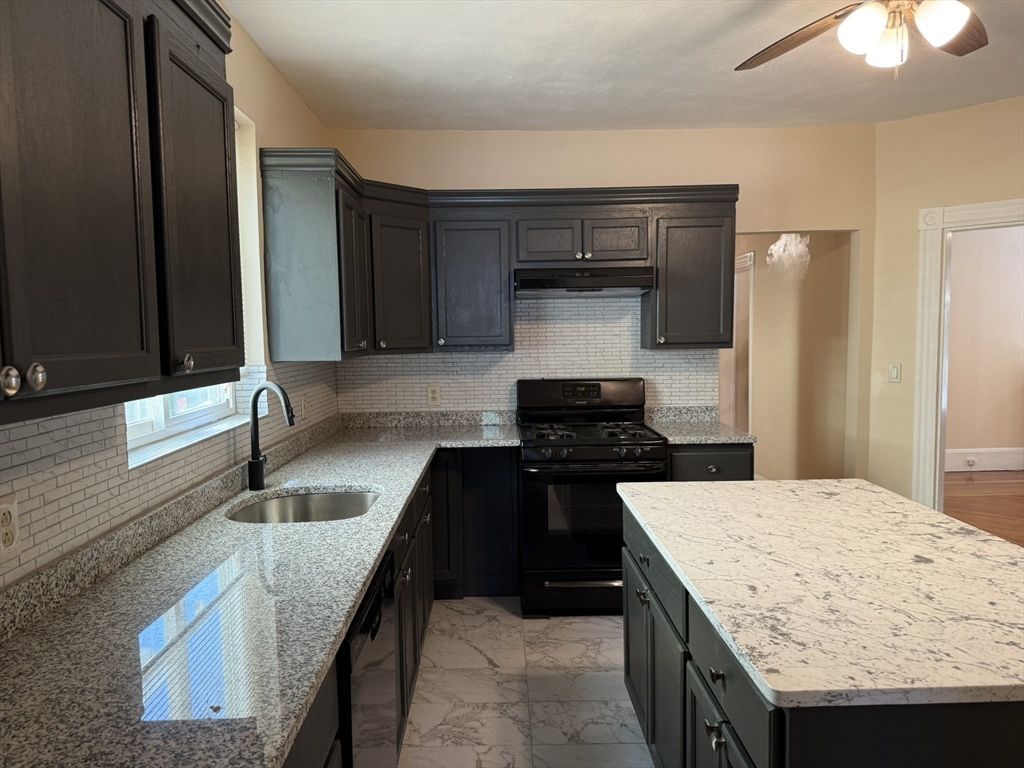 4 Dever Street, Unit 1 Boston, MA 02122 - Photo 3 of 22 a kitchen with granite countertop a sink and a stove