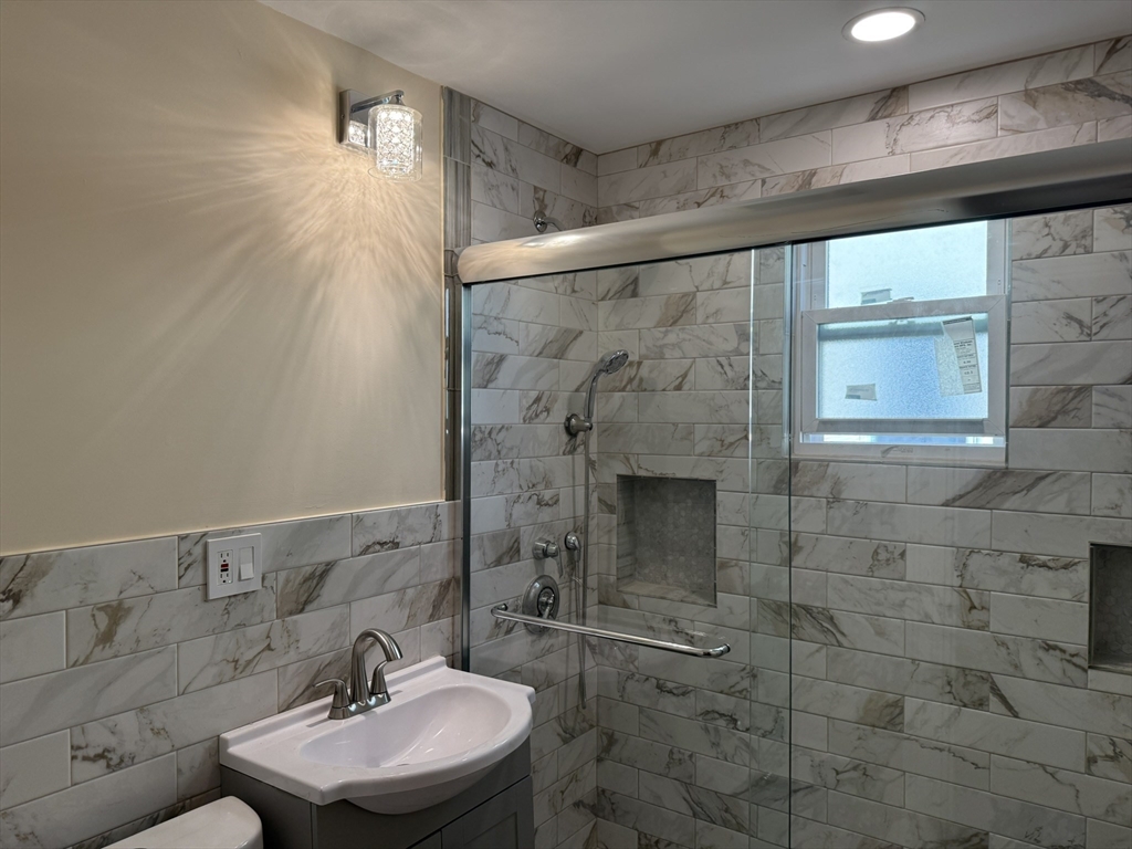 4 Dever Street, Unit 1 Boston, MA 02122 - Photo 9 of 22 a bathroom with a sink mirror and shower