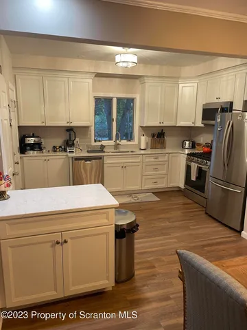 a kitchen with cabinets appliances a sink and a counter top space