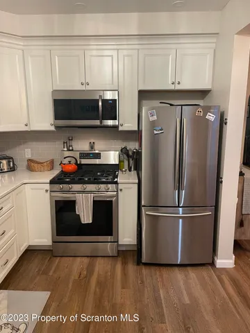 a kitchen with stainless steel appliances granite countertop a refrigerator a stove a microwave and cabinets