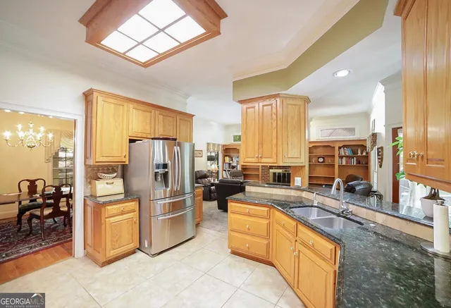 a kitchen with granite countertop a refrigerator stove and sink