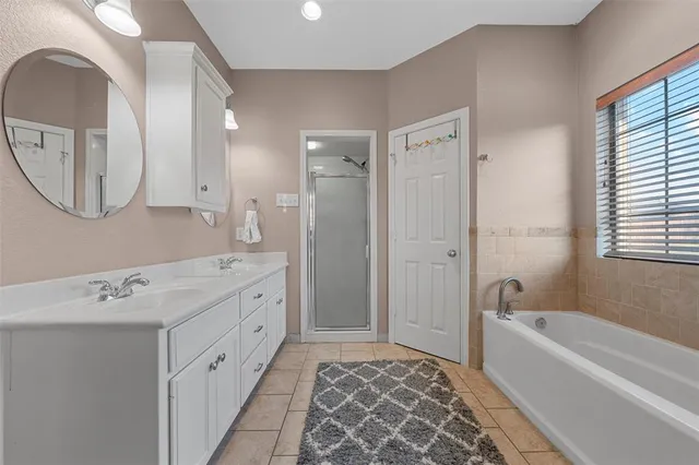 a bedroom with a bed and a flat tv screen on the dresser