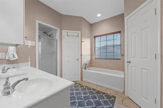 a bathroom with a tub a sink and a mirror