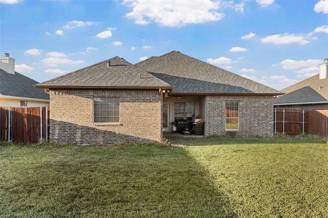 a view of a house with backyard and sitting area