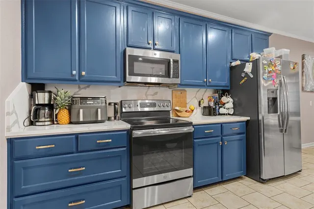 a kitchen with stainless steel appliances granite countertop wooden cabinets a stove top oven a refrigerator and dishwasher with wooden floor