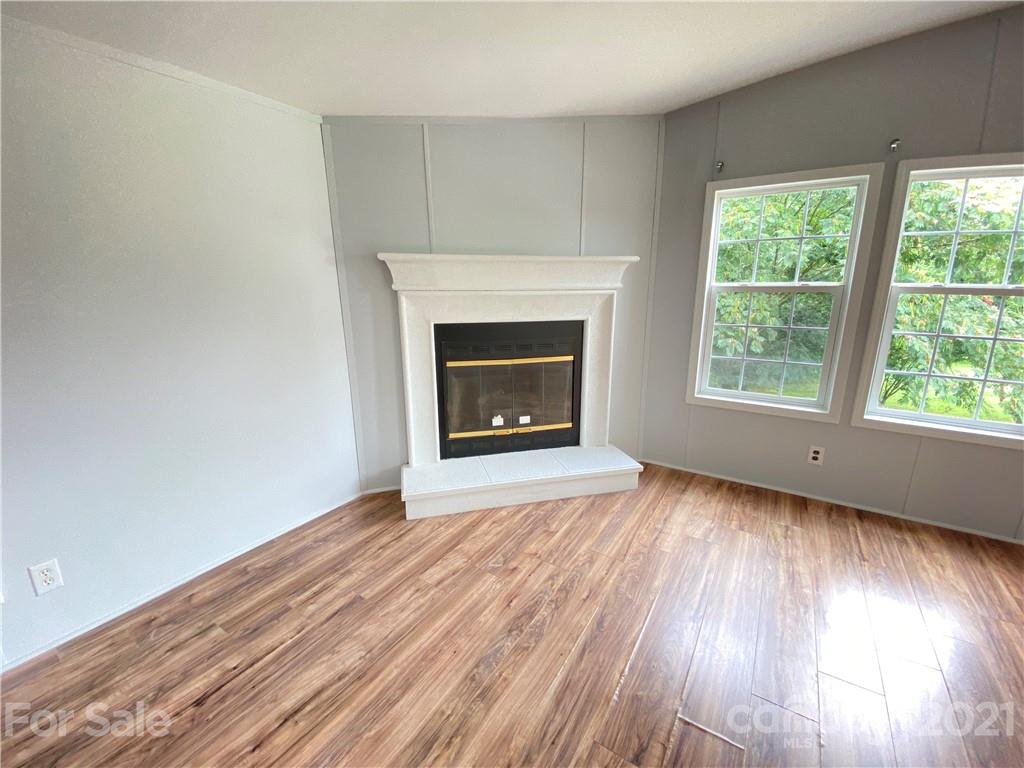 7210 Medlin Road Monroe, NC 28112 - Photo 29 of 30 an empty room with wooden floor fireplace and windows