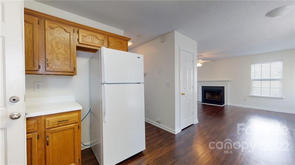 8821 Cameron Spring Road Charlotte, NC 28214 - Photo 17 of 40 a view of a kitchen with wooden floor and a refrigerator