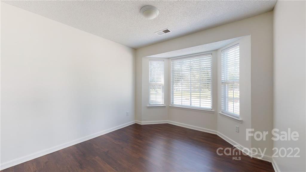 8821 Cameron Spring Road Charlotte, NC 28214 - Photo 19 of 40 a view of an empty room with wooden floor and a window