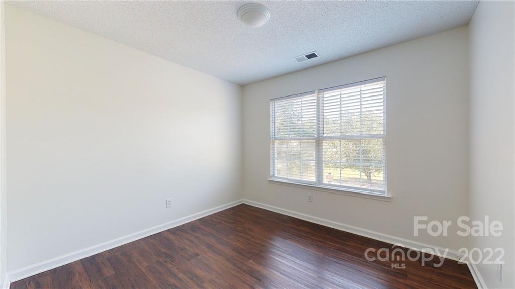 8821 Cameron Spring Road Charlotte, NC 28214 - Photo 22 of 40 an empty room with wooden floor and windows
