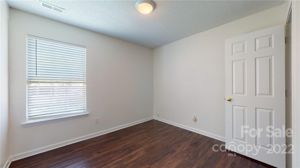8821 Cameron Spring Road Charlotte, NC 28214 - Photo 24 of 40 an empty room with wooden floor and windows