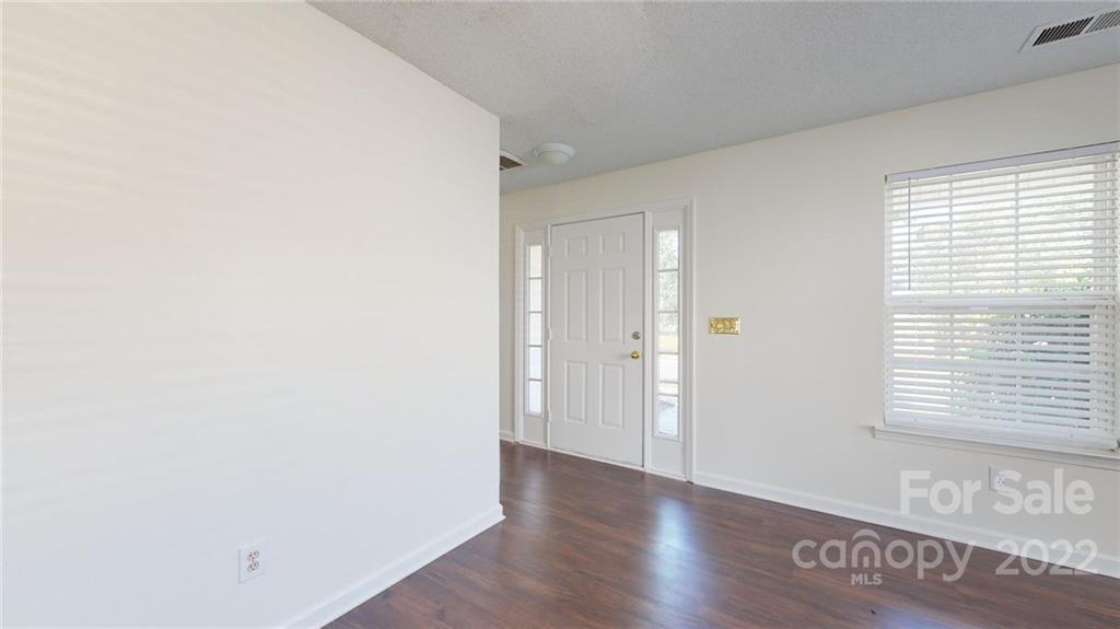8821 Cameron Spring Road Charlotte, NC 28214 - Photo 7 of 40 a view of an empty room with wooden floor and a window