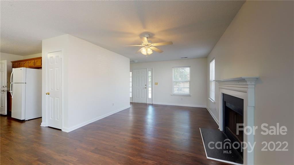 8821 Cameron Spring Road Charlotte, NC 28214 - Photo 10 of 40 a view of an empty room with wooden floor fireplace and a window