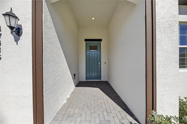 a view of a hallway with wooden floor and a bathroom
