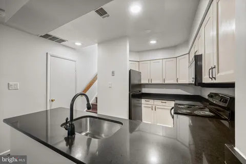 a kitchen with stainless steel appliances granite countertop a sink a stove and a refrigerator
