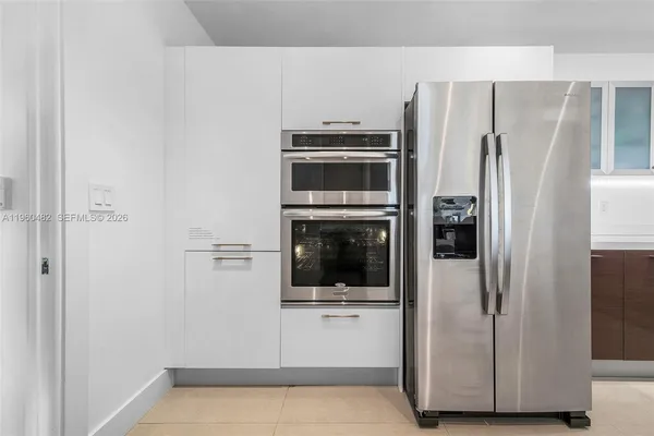 a view of a kitchen with a refrigerator a microwave and a sink