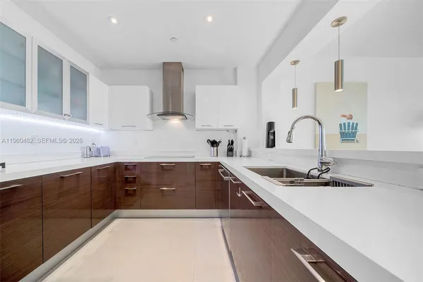 a kitchen with kitchen island granite countertop a sink stainless steel appliances and cabinets