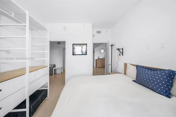 a large bedroom with a bed and a large window