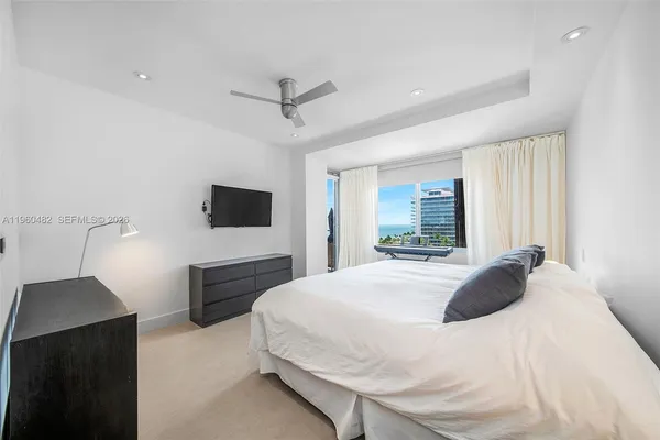 a bedroom with a bed and a flat tv screen on wall