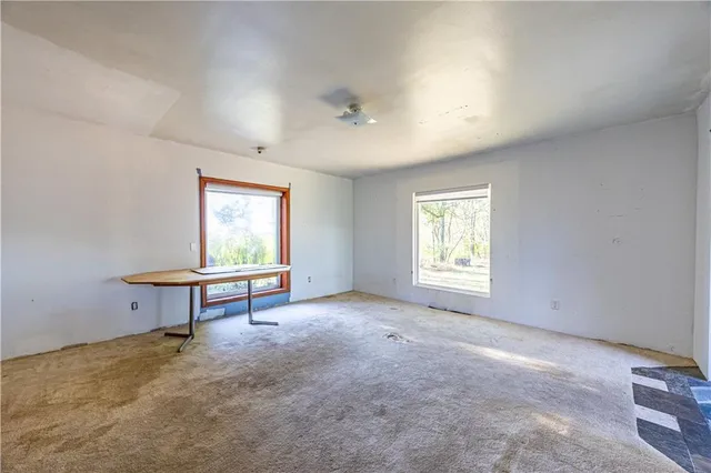 a view of a room with windows a ceiling fan and a window