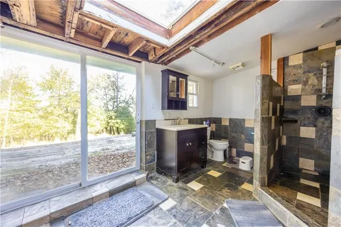a bathroom with a granite countertop sink a mirror and shower