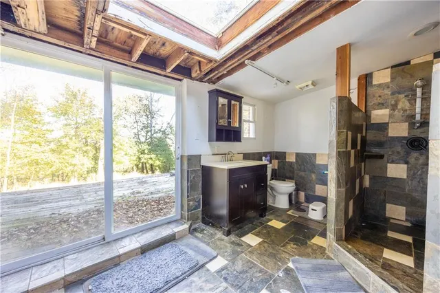 a bathroom with a granite countertop sink a mirror and shower