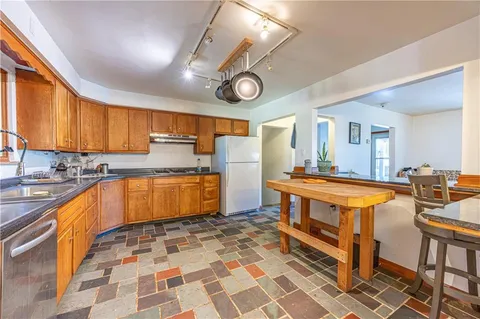 a large kitchen with stainless steel appliances a stove a sink and a cabinets