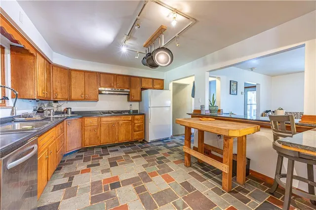 a large kitchen with stainless steel appliances a stove a sink and a cabinets