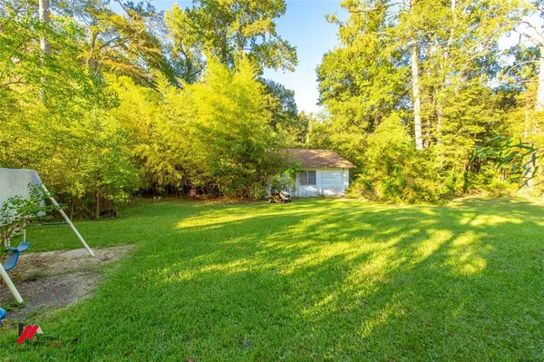 a view of house with a backyard