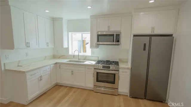 a kitchen with stainless steel appliances granite countertop a stove a sink and a refrigerator