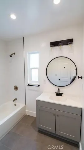 a bathroom with a sink a mirror a bathtub and shower