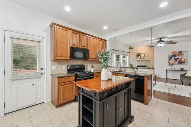 a kitchen with stainless steel appliances granite countertop a stove top oven a sink dishwasher and a refrigerator