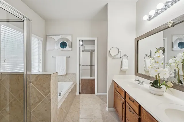 a bathroom with a double vanity sink mirror and shower